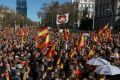 Los manifestantes ondean banderas nacionales españolas en una protesta en Madrid contra el gobierno de izquierda de España