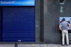 Un hombre utiliza un cajero automático en una sucursal del banco Sabadell en la localidad vasca de Guernica.