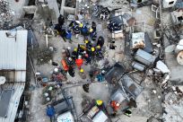 Los rescatistas intentan liberar a un niño atrapado bajo los escombros, tras el mortal terremoto en Hatay