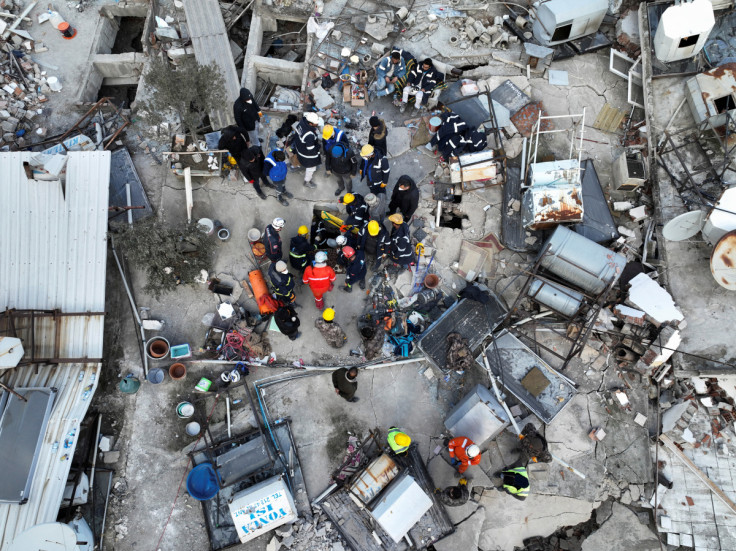 Los rescatistas intentan liberar a un niño atrapado bajo los escombros, tras el mortal terremoto en Hatay