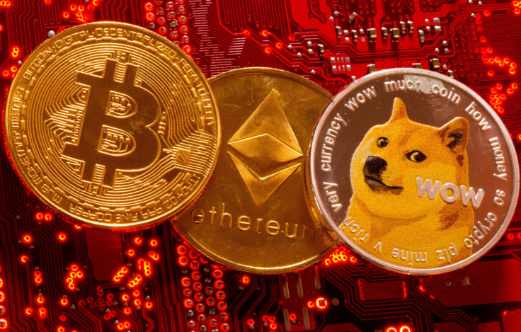Las representaciones de las criptomonedas Bitcoin, Ethereum y DogeCoin se colocan en la placa base de la PC en esta ilustración tomada