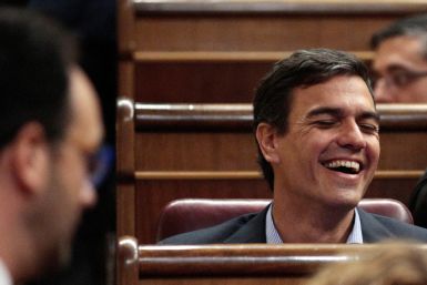 El exlíder del PSOE Sánchez se ríe frente al portavoz parlamentario socialista Hernando durante el debate de investidura en el Parlamento de Madrid.