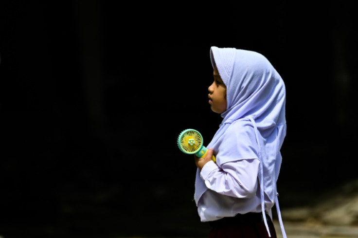 Un estudiante de primaria usa un ventilador portátil para mantenerse fresco durante el clima cálido en Banda Aceh, Indonesia, el 15 de mayo de 2023.